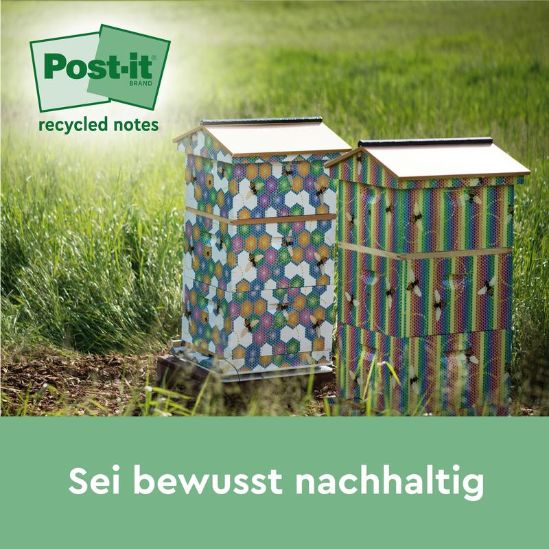 To farverige bistader med sekskantede mønstre står på en eng i sollyset. I hjørnet står logoet for Post-it® genbrugssedler, 38 mm x 51 mm, 100 ark/blok, 100% PEFC af 3M Deutschland GmbH. Teksten nedenfor lyder: "Vær bevidst bæredygtig.