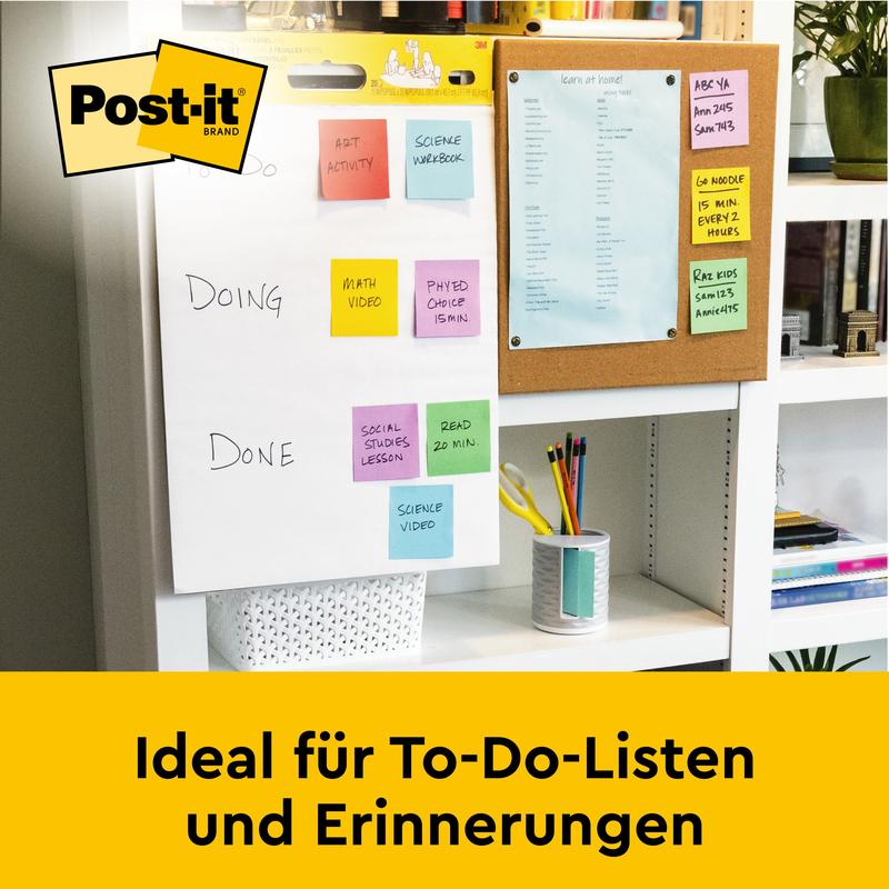 På skrivebordet står et Post-it® Super Sticky selvklæbende mødeplanchart/flipchart fra 3M Deutschland GmbH (hvid, 63,5x76,2cm), perfekt til to-do-lister & påmindelser. I baggrunden: en opslagstavle med blåt papir.