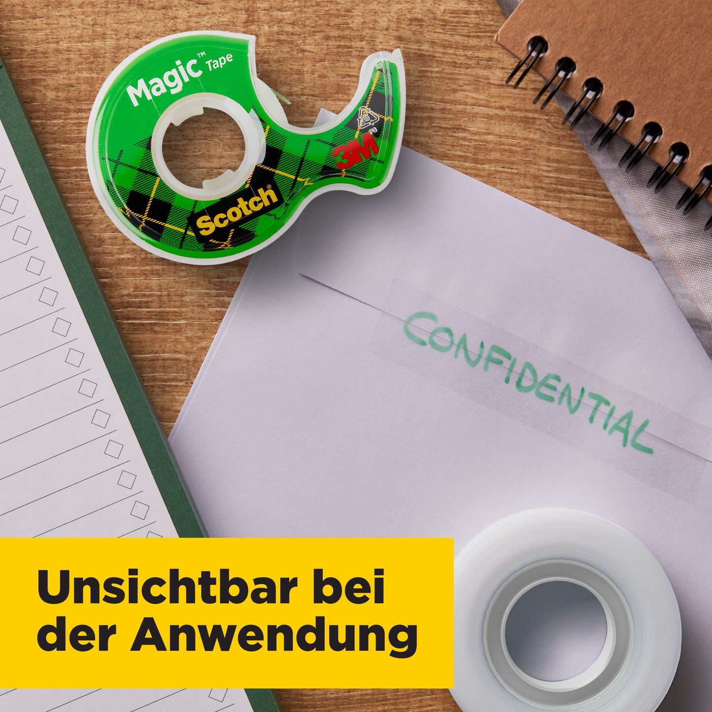 Eine Rolle Scotch® Magic™ Unsichtbares Klebeband (19 mm x 25 m, mit Handabroller und 5 m GRATIS) von 3M Deutschland GmbH liegt neben einem Notizbuch, "CONFIDENTIAL"-Umschlag und Abroller. Unsichtbar bei der Anwendung.