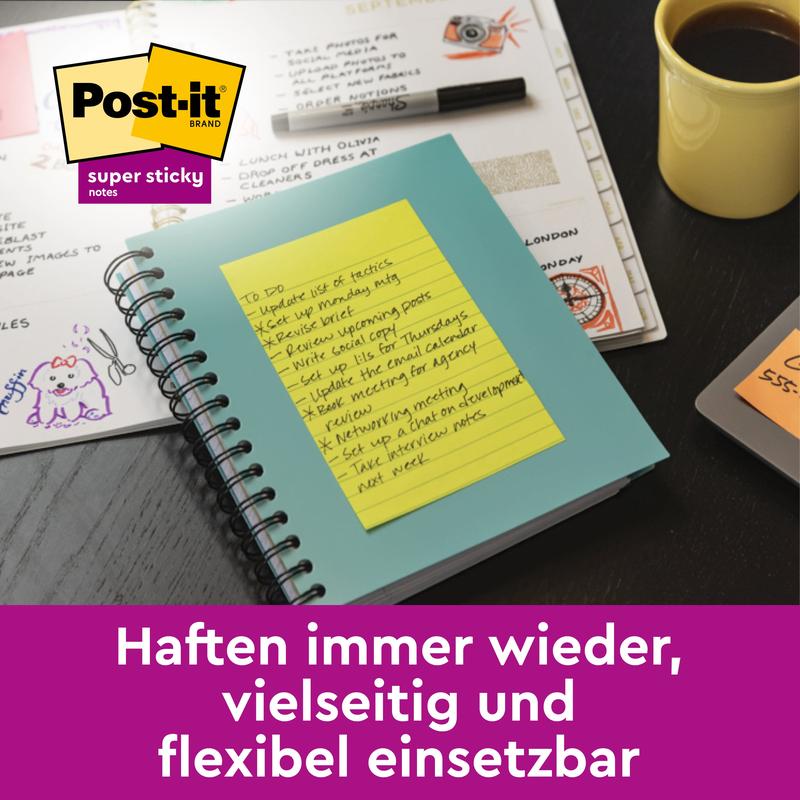 En pakke 3M Deutschland GmbH Post-it® Super Sticky Meeting Notes i forskellige farver (203 x 153 mm, 45 ark/blok, 6 blokke/pakke, PEFC-certificeret) ligger ved siden af kalender, tastatur, pen og kaffe - alsidig og genanvendelig til enhver opgave.