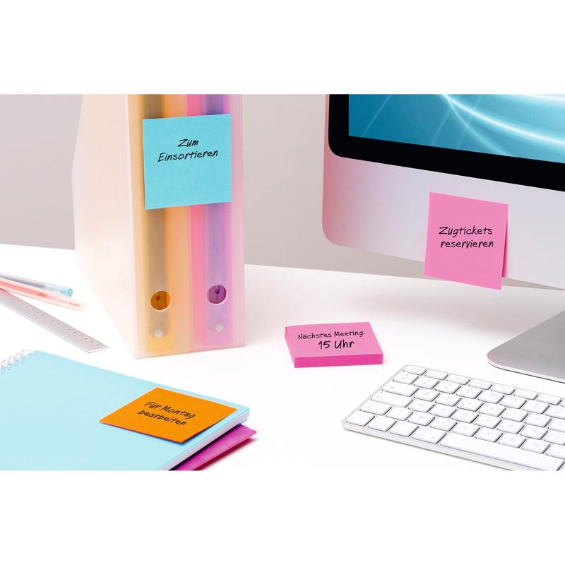 Et ryddeligt skrivebord med to ringbind, en skærm, et tastatur, en lineal, en notesbog og farverige Post-it® Super Sticky Notes (76 mm x 127 mm, 90 ark/blok, 100% PEFC) fra 3M Deutschland GmbH med håndskrevne danske påmindelser.