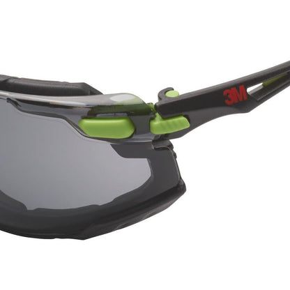 Nærbillede af 3M™ Solus™ beskyttelsesbrille 1000 fra 3M Deutschland GmbH, med gråt glas, grøn/sort ramme med aftagelig skumforsegling og Scotchgard™ Protector antidug-belægning for optimal øjenbeskyttelse.