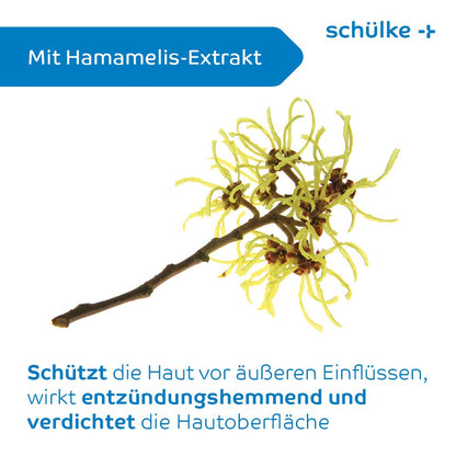 På en hvid baggrund er der afbildet en gren af hamamelis med gule blomster. Teksten lyder »Med hamamelis-ekstrakt« og beskriver på tysk de hudbeskyttende fordele, herunder lindring af hudirritationer. På emballagen til Schülke sensiva® beskyttelsescreme står der »Schülke & Mayr GmbH« med blå skrift.